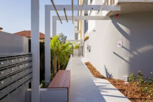 One of the shared areas at the Ironbark Place apartment. It has bench seats, shade and landscaping.